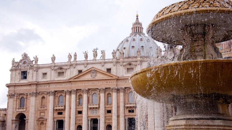 Basílica de São Pedro no Vaticano com cúpula de Michelangelo e fonte jorrando água na Praça de São Pedro, Roma