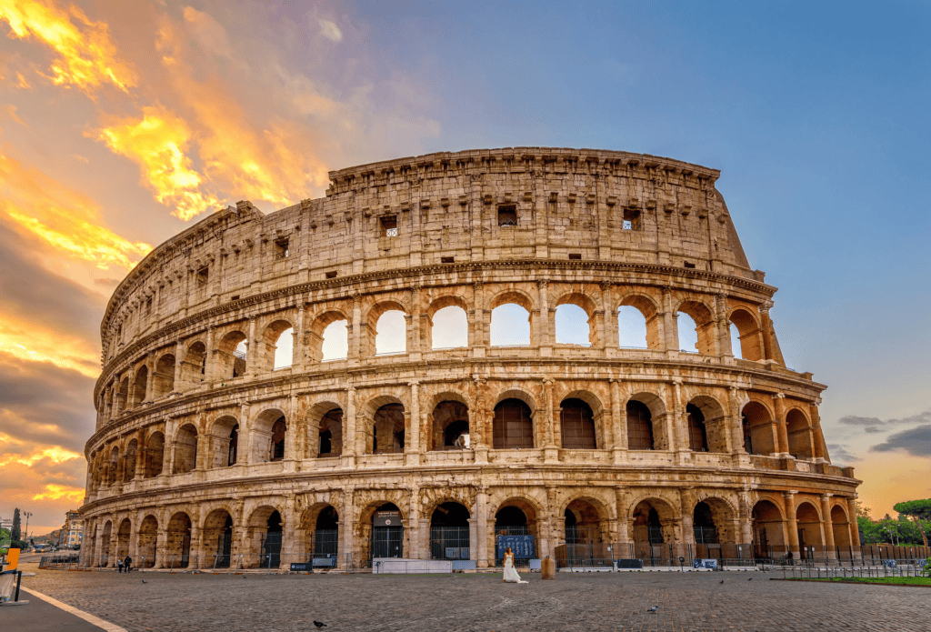 Coliseu de Roma ao pôr do sol com céu dourado e nuvens dramáticas, anfiteatro romano antigo, Roma, Itália