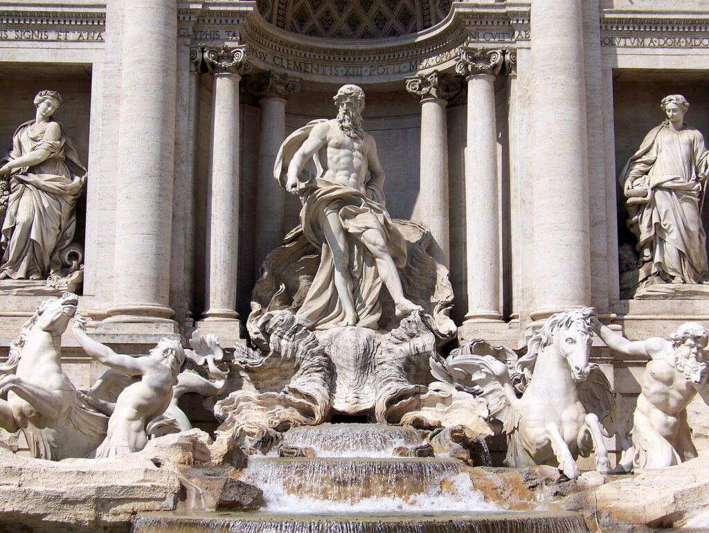 Detalhe das esculturas da Fontana di Trevi em Roma mostrando Netuno/Oceanus no centro, colunas coríntias, cavalos marinhos e estátuas mitológicas em mármore branco com água
