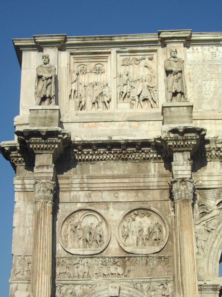 Arco de Constantino Roma mostrando detalhes dos relevos e esculturas romanas antigas incluindo painéis retangulares superiores, medalhões circulares (tondi), estátuas em nichos, colunas coríntias e inscrições latinas