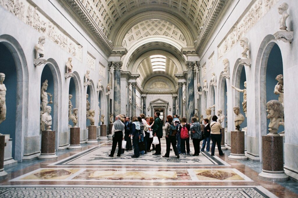 Interior do Braccio Nuovo no Museu Chiaramonti dos Museus do Vaticano, corredor com estátuas clássicas em nichos, bustos e colunas de mármore