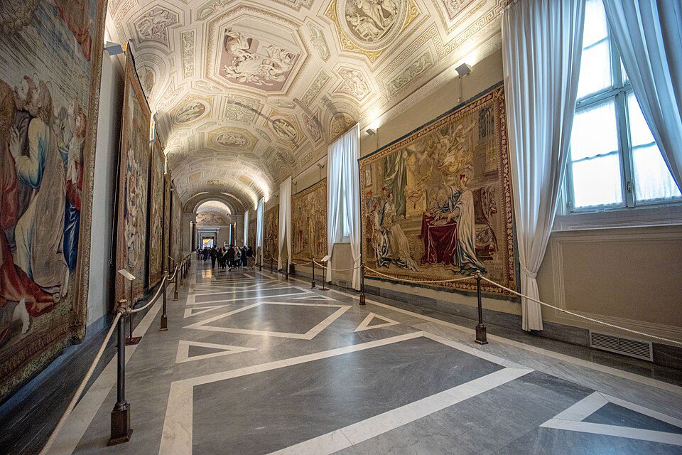 Galleria degli Arazzi nos Museus do Vaticano, corredor com tapeçarias renascentistas nas paredes e teto decorado com afrescos