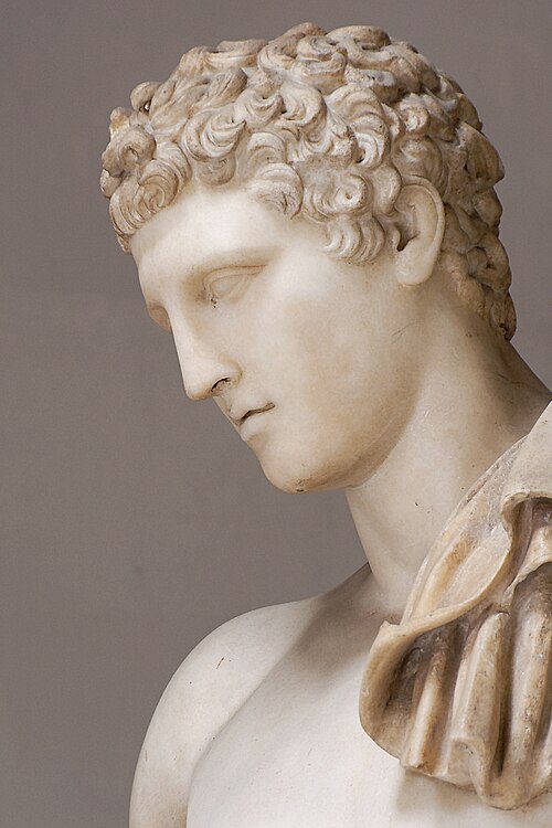 Estátua Hermes de Andros, escultura clássica de mármore com cachos detalhados, exposta no Museu Pio-Clementino dos Museus do Vaticano